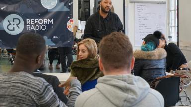 Group of young people in a classroom, with banner saying Reform Radio